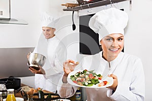 Woman chef serving fresh salad