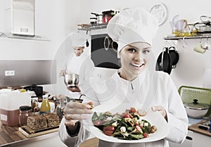 Woman chef serving fresh salad