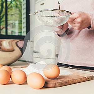 Woman Chef sifts flour, knead the dough. Bakery or Baking Concept. Ingredients for dough