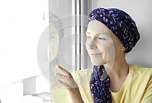 Woman after chemotherapy near window at home