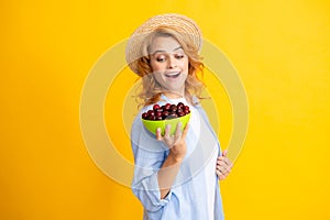 Woman with cherry, organic fruits. Cherries and harvesting in summer. Girl picking and eating ripe cherries, fresh