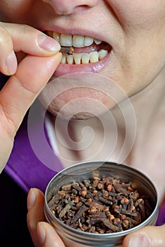 Woman chew dried clove spice