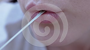 Woman Chews Chewing Gum Stretches it in Length with Fingers. Zoom. Close up
