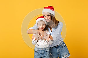 Woman child baby girl 4-5 years old in Christmas Santa hat. Mommy little kid daughter isolated on yellow background