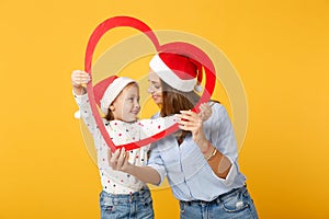 Woman child baby girl 4-5 years old in Christmas Santa hat. Mommy little kid daughter isolated on yellow background