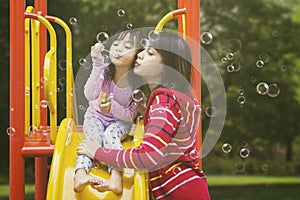 Woman and child blow soap bubbles