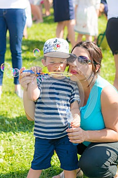 Woman and child blowing soap bubbles