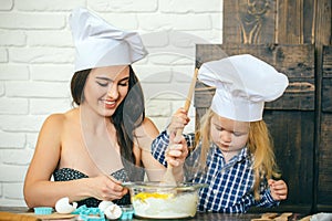 Woman and child boy in chef hats with spoon