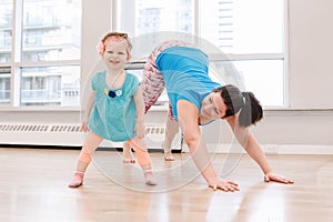 Woman with child boy son doing workout in gym class to loose baby weight.