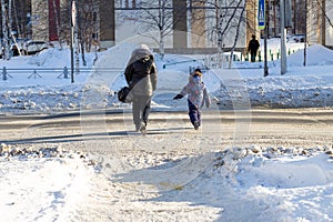 A woman with a child crosses the road unsafe