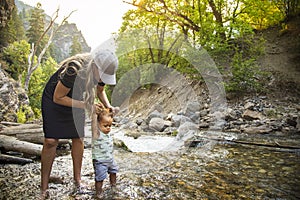 Woman and child hiking across a beautiful scenic mountain river