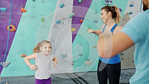 Woman, child and man training in climbing gym smiling enjoying active leisure