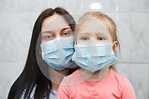 Quarantined woman and child in medical masks. Baby in the focus photo