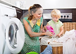 Woman with child near washing machine