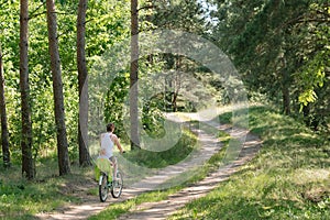 Woman with a child rides a bicycle in nature. Summer holiday with bicycle. Outdoor sport activity