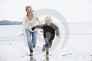 Woman and child running on beach