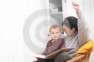 A woman and a child are sitting together and reading a book