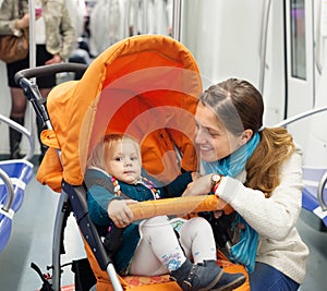 Woman with child in stroller at subway