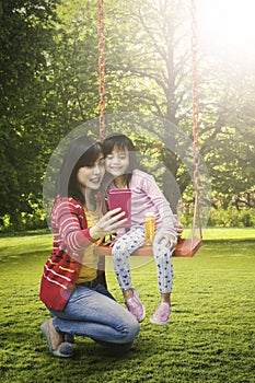 Woman and child taking selfie at park