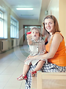 Woman with child with urinalysis sample photo
