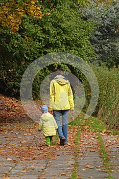Woman with child walking in autumn park