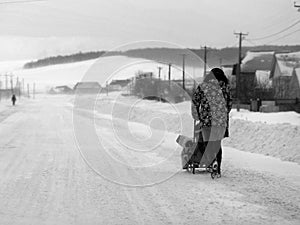 Woman and Child Walking in Winter Snow Storm on Street