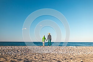 A woman with a child walks along the sea coast