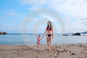 Woman and childholding hands on Beach