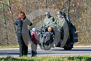 A woman and children look at three military men in retro uniform