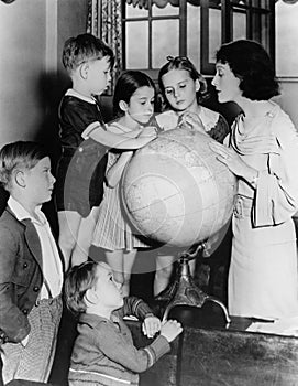 Woman and children looking at globe