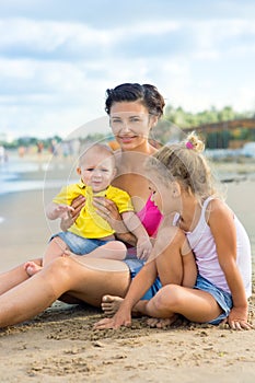 Woman with children playing on the beach