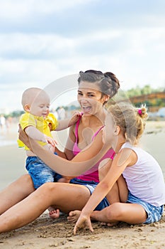 Woman with children playing on the beach