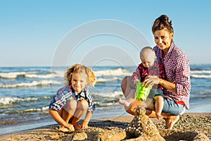 Woman with children playing on the beach