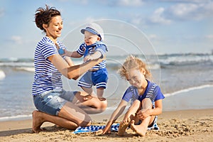 Woman with children playing on the beach