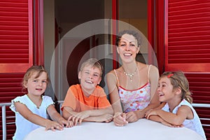 Woman with children sits in number on verandah photo