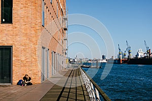 Woman chilling with a book on a quay of the port of Hamburg