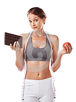 Woman, chocolate and apple with choice and tape measure for diet, weight loss and snack balance on white background