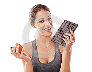 Woman, chocolate and apple with comparison in portrait, weight loss and balance with snacks on white background