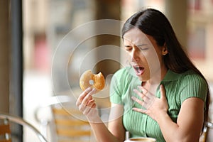 Woman choking eating doughnut in a bar