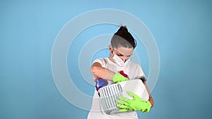 Woman chooses cleaning products in the basket.Brunette holding cleaning backet