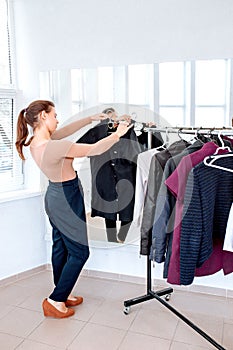 Woman chooses clothes on a hanger