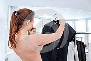 Woman chooses clothes on a hanger