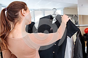 Woman chooses clothes on a hanger