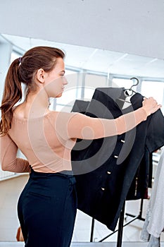 Woman chooses clothes on a hanger