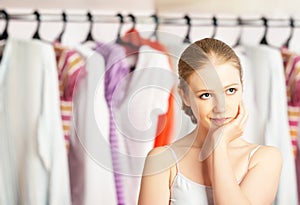 Woman chooses clothes in the wardrobe closet at home