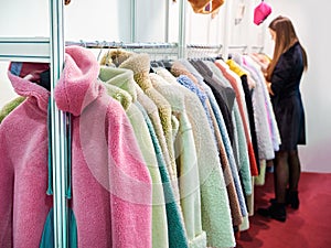 Woman chooses faux fur clothing in store