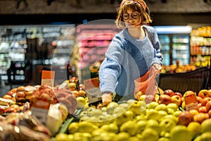 Woman chooses fruits at supermarket