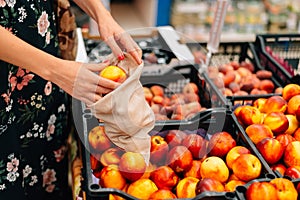 Woman is chooses fruits and vegetables food market. Reusable bag shopping. Zero waste
