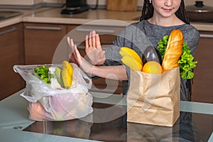 Woman chooses a paper bag with food and refuses to use plastic. Concept of environmental protection