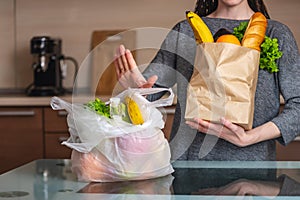 Woman chooses a paper bag with food and refuses to use plastic. Environmental protection and the abandonment of plastic